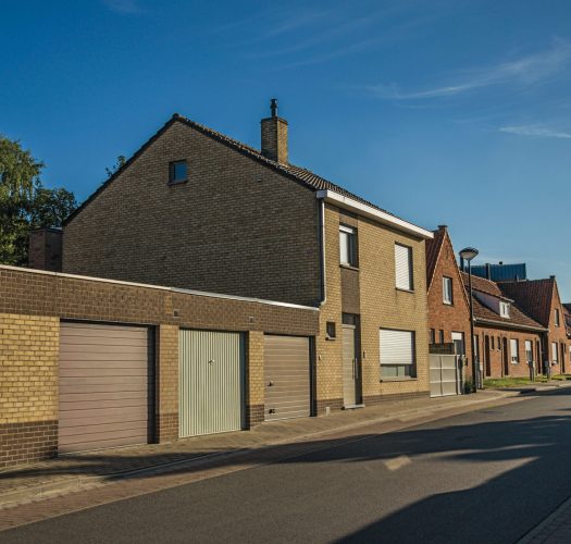 Street with brick houses at sunset and blue bright sky in Tielt.